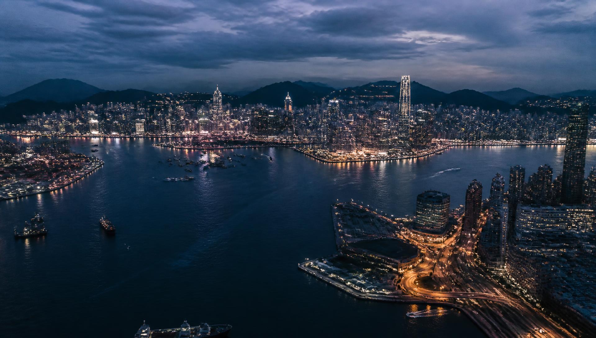 Aerial view of a fast-growing city at dusk with light trails across its arteries